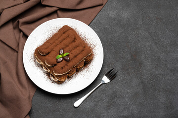Classic tiramisu dessert on ceramic plate on concrete background