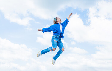Naklejka na ściany i meble happy childhood. smiling child jumping so high. carefree and joyful. kid fashion style. teenage girl on sky background outdoor. hipster kid jump. happy childrens day. Looking trendy