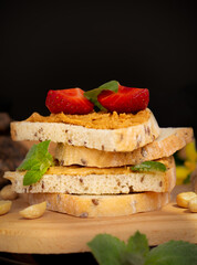 peanut butter wholegrain sandwich with strawberries, healthy nutrition concept, black background