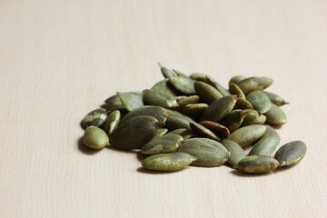 Pumpkin Seeds on Wood Background.