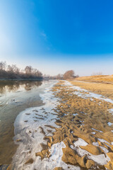 Hoarfrost and fresh powder snow in winter, on a wild, beautiful, river bank