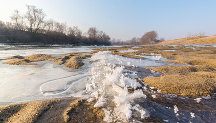 Hoarfrost and fresh powder snow in winter, on a wild, beautiful, river bank
