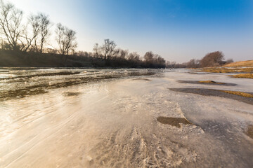 Winter scenery with a wild river, surrounded by frost and fresh snow
