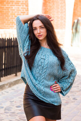Woman in green handmade knitted sweater posing in the old city
