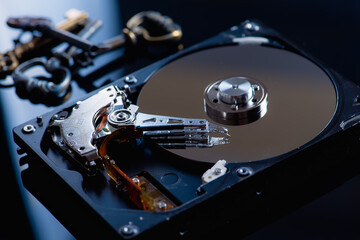Hard drive or hard drive on a black reflex background, information protection next to it lie antique metal keys, low key, there is a place for the inscription 