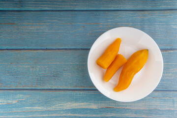 Ubi rebus or steam cassava is traditional malay dish on wooden background. Selective focus