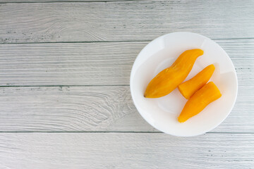 Ubi rebus or steam cassava is traditional malay dish on wooden background. Selective focus