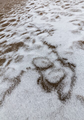 Abstract shapes with sand dunes covered by fresh powder snow, in a wild river bed, in winter
