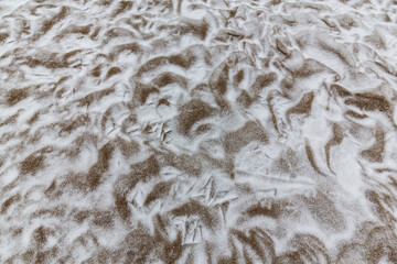 Abstract shapes with sand dunes covered by fresh powder snow, in a wild river bed, in winter