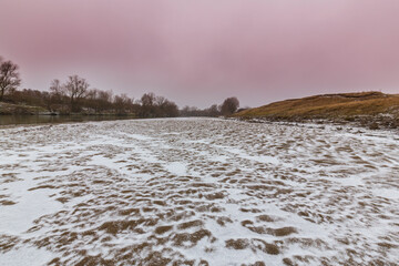Abstract shapes with sand dunes covered by fresh powder snow, in a wild river bed, in winter