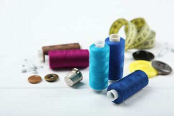 different sewing accessories on the table. Threads, needles, pins, fabric and sewing scissors close up
