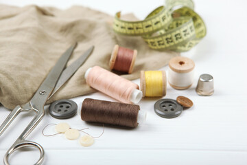 Fototapeta na wymiar different sewing accessories on the table. Threads, needles, pins, fabric and sewing scissors close up 