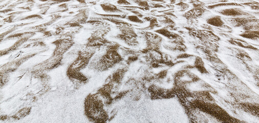 Abstract shapes with sand dunes covered by fresh powder snow, in a wild river bed, in winter