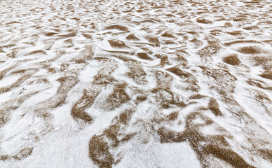 Abstract shapes with sand dunes covered by fresh powder snow, in a wild river bed, in winter