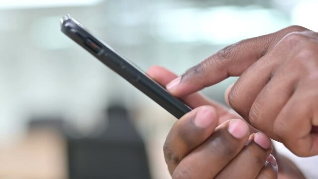 Close Up of African Hand Text Messaging on Smartphone