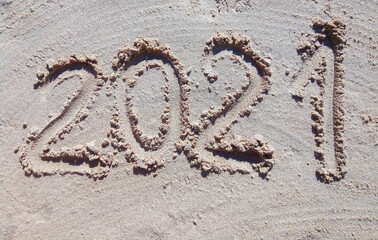 2021 inscription on the sand of the beach. Summer beach holidays in 2021. The message is handwritten
