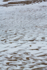 Abstract shapes with sand dunes covered by fresh powder snow, in a wild river bed, in winter