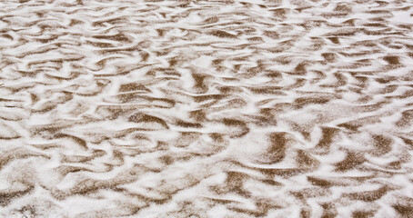 Abstract shapes with sand dunes covered by fresh powder snow, in a wild river bed, in winter