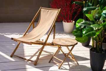 Comfortable bamboo chair and table, plants outdoor.
