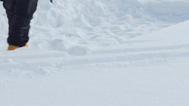 Igloo. A man picks up a carved snow block to build an Igloo.