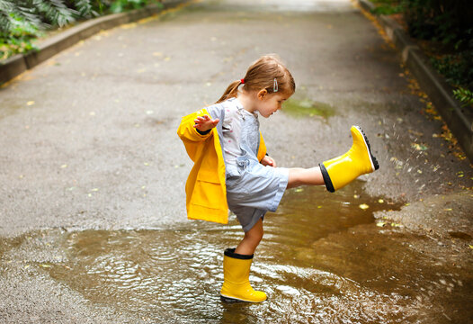 Little girl wearing yellow boots and coat in rainy day