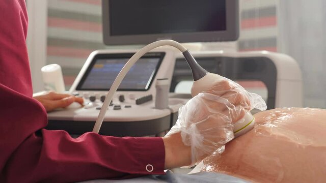 Pregnancy and Healthcare concept. Obstetric Ultrasound scans. Ultrasound investigation of pregnant woman. Doctor doing 3d ultrasound on belly in clinic. Process of fetus ultrasonography. 4 k video