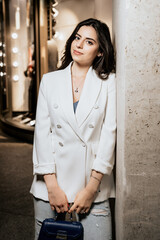 Vertical photo of attractive woman wearing white fashion jacket and jeans look in camera. Young...