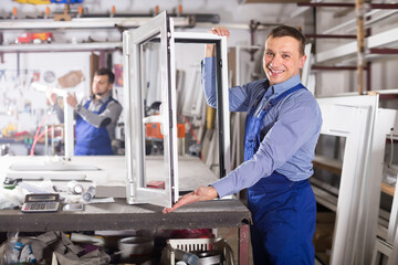 Happy production workers in coverall with different PVC windows and doors