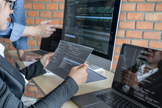 Two professional programmer cooperating and working on web site project in a software developing on desktop computer at company, codes and typing data code, Programming with HTML, PHP and javascript