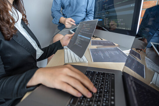 Programmers cooperating at Developing programming and website working in a software develop company office, writing codes and typing data code, Programming with HTML, PHP and javascript