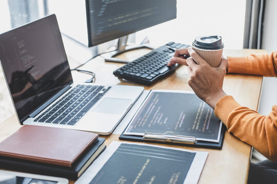 Young Professional programmer working at developing programming and website working in a software develop company office, writing codes and typing data code, Programming with HTML, PHP and javascript