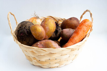 Basket of vegetables, heart potatoes, onions, carrots and beets. The concept of harvest
