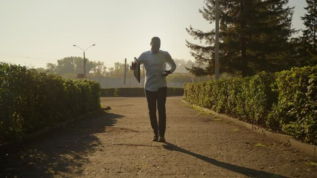 Successful African American business man walks down the street and uses a smartphone to check social networks.