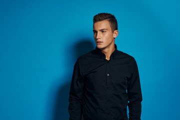 Obraz premium emotional man in black shirt studio lifestyle blue isolated background