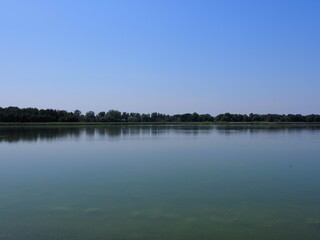 Desolate artificial pond in european Goczalkowice town at Silesian district in Poland, clear blue sky in 2020 warm sunny spring day on June.