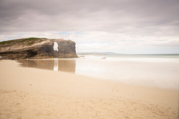 Stone arch in Las catedrales beach in galicia, spain