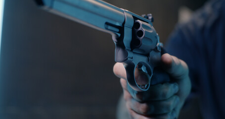 Unrecognizable man reloading revolver in shooting range - obrazy, fototapety, plakaty