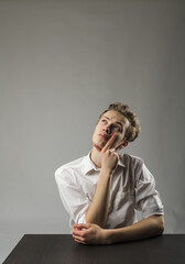 Young man in white is full of doubts and hesitation.