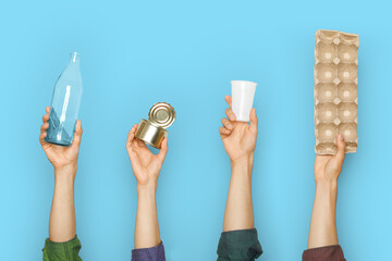 Different types of waste in the hands on a blue background. - Powered by Adobe