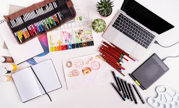 Artist workspace with laptop, tablet and drawing tools top view flat lay