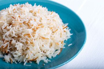 Cooked basmati rice served in a ceramic bowl or plate on white background.