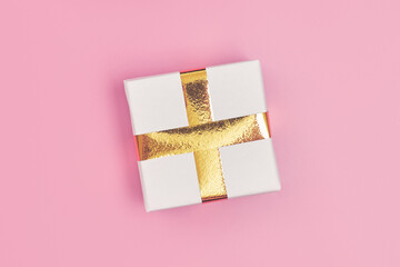 christmas gift with gold ribbon on pink background isolate, copy space, layout