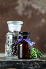 Oregano essential oil in glass bottle on wooden background. copy space