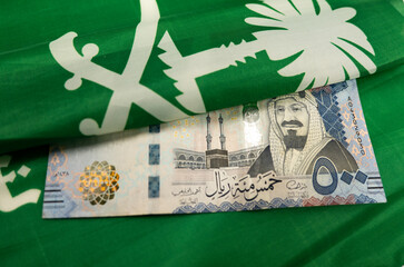 500 Saudi Riyal Bank note with flag of Saudi Arabia in background
