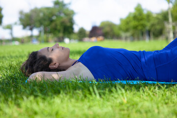 Beautiful young woman lying on the grass