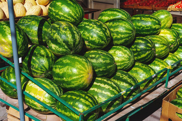 a lot of watermelons are on the counter in a vegetable store