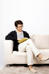 Fototapeta na wymiar young man reading a book on sofa