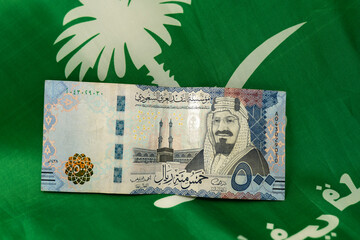 500 Saudi Riyal Bank note in front of Saudi Arabia flag 