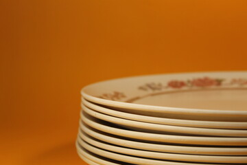 side view of ceramic food plates with orange background