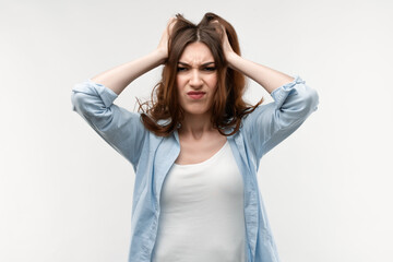 Obraz premium Photo of brunette female with long straight hair, holding hands on head. Problems, surprise, fear, fobia concept